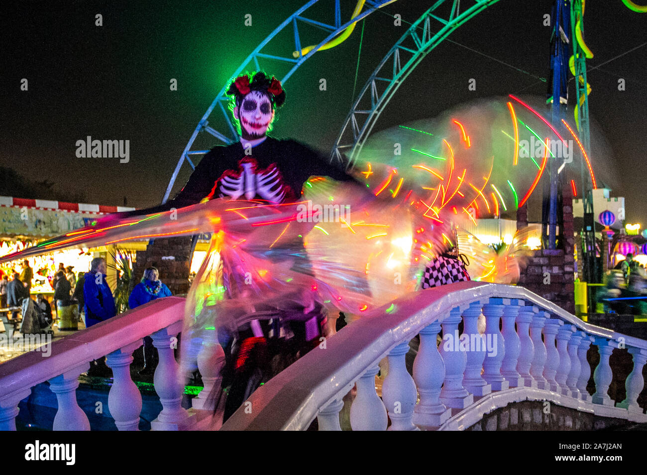Wings over water LED wispy display elegant skeletal figure at the Day Of The Dead Festival – November the host month to Mexico's Day of the Dead. Southport Pleasureland staged its own twist on the spooky Mexican celebration with explosive cascade of colours and patterns created while dancing moving with light, bright, digital, loop design, motion, pattern and vibrant revelry in a feast for the senses.  A host of fantastic entertainment & celebrations brought thousands of tourists to the resort to enjoy the spectacle. Stock Photo