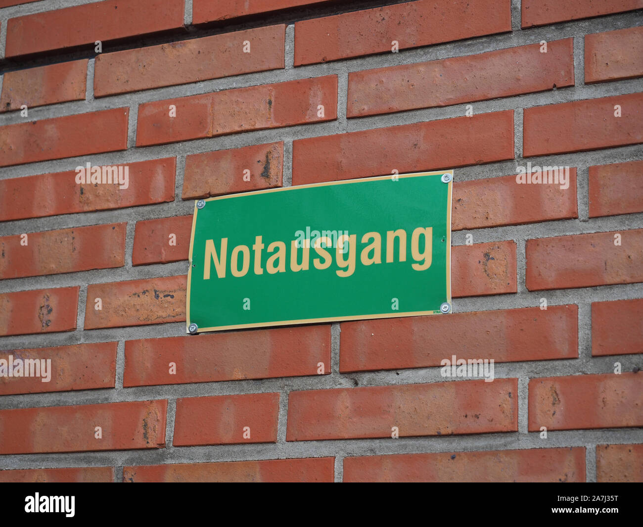 notausgang-meaning-emergency-exit-sign-on-red-brick-wall-stock-photo