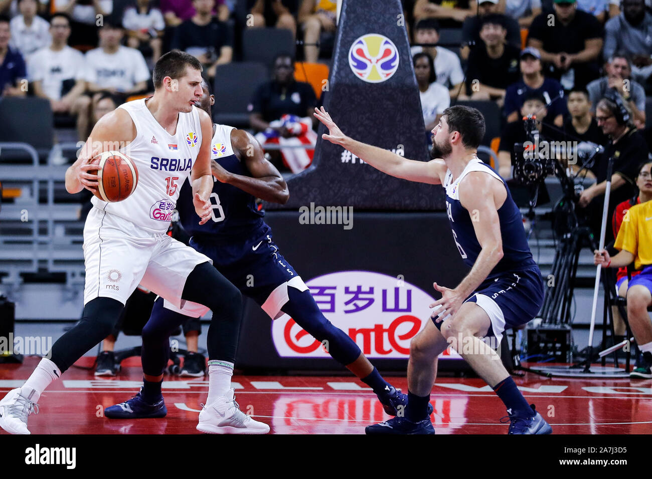 Nikola Jokic of Serbia, left, keeps the ball during the 5th – 8th classification round against the United States of FIBA Basketball World Cup in Dongg Stock Photo