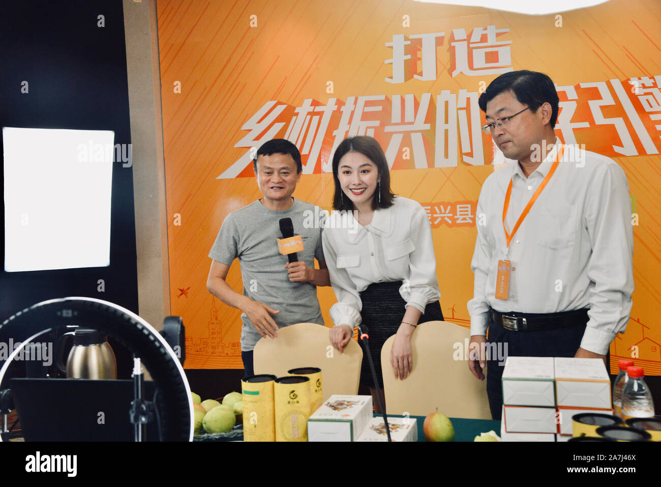 Jack Ma, left, speaks in front of the camera at the online host, middle, Kikis live-streaming event for selling Binzhou farm products in Binzhou city Stock Photo