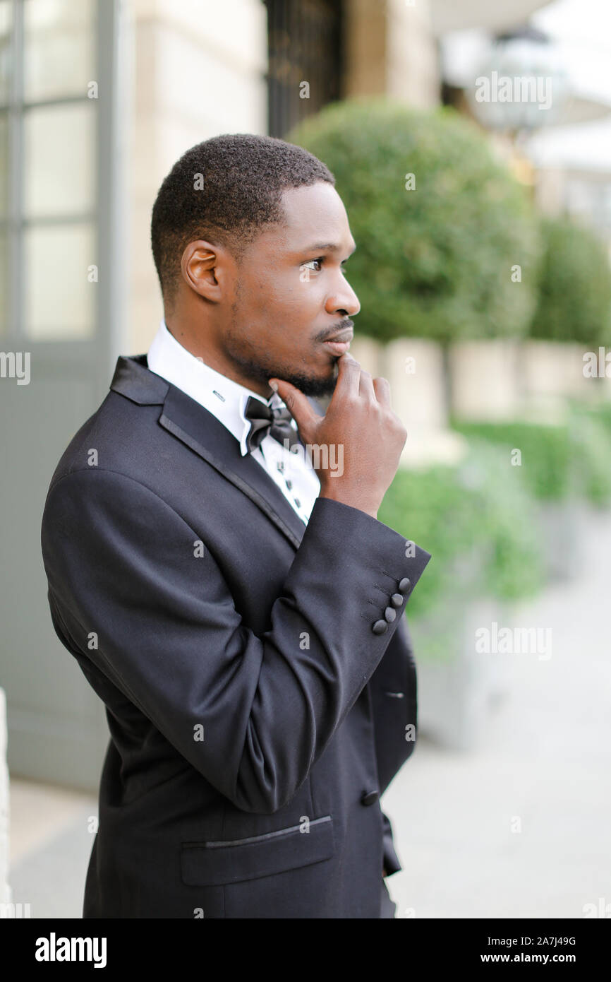 Afro american happy good looking man wearing suit and standing outside ...