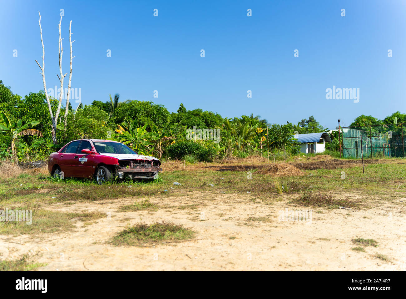 An old car left abandoned on an empty field Stock Photo