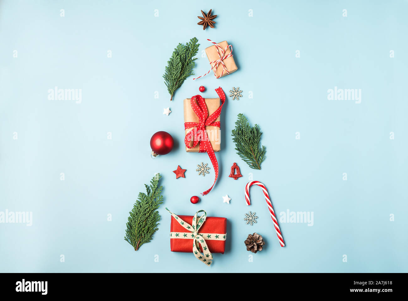 christmas tree made from fir branches, winter decorations, candy and gift boxes on blue background. holiday creative concept. new year or christmas ba Stock Photo