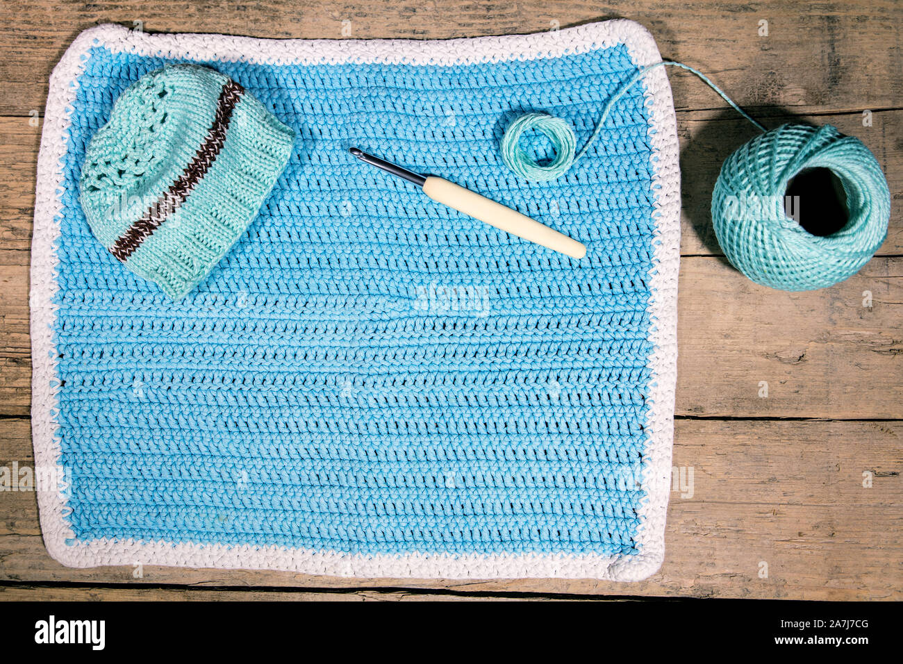 Flatlay, crocheted cloth, yarn, crochet hook, blue handiwork background Stock Photo