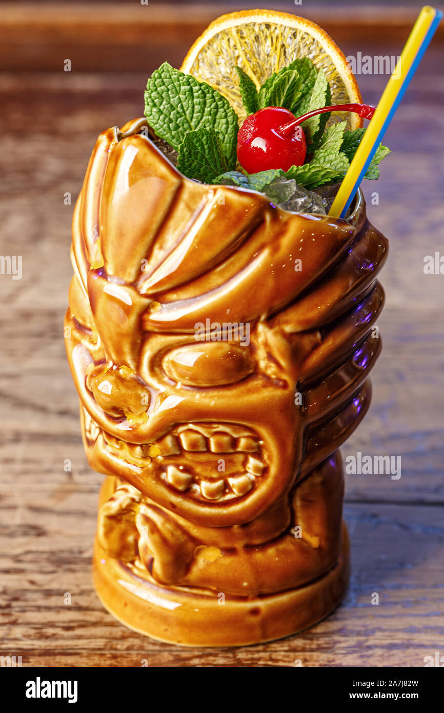 Exotic cocktail in tiki glass rum runner decorated with cherry, mint