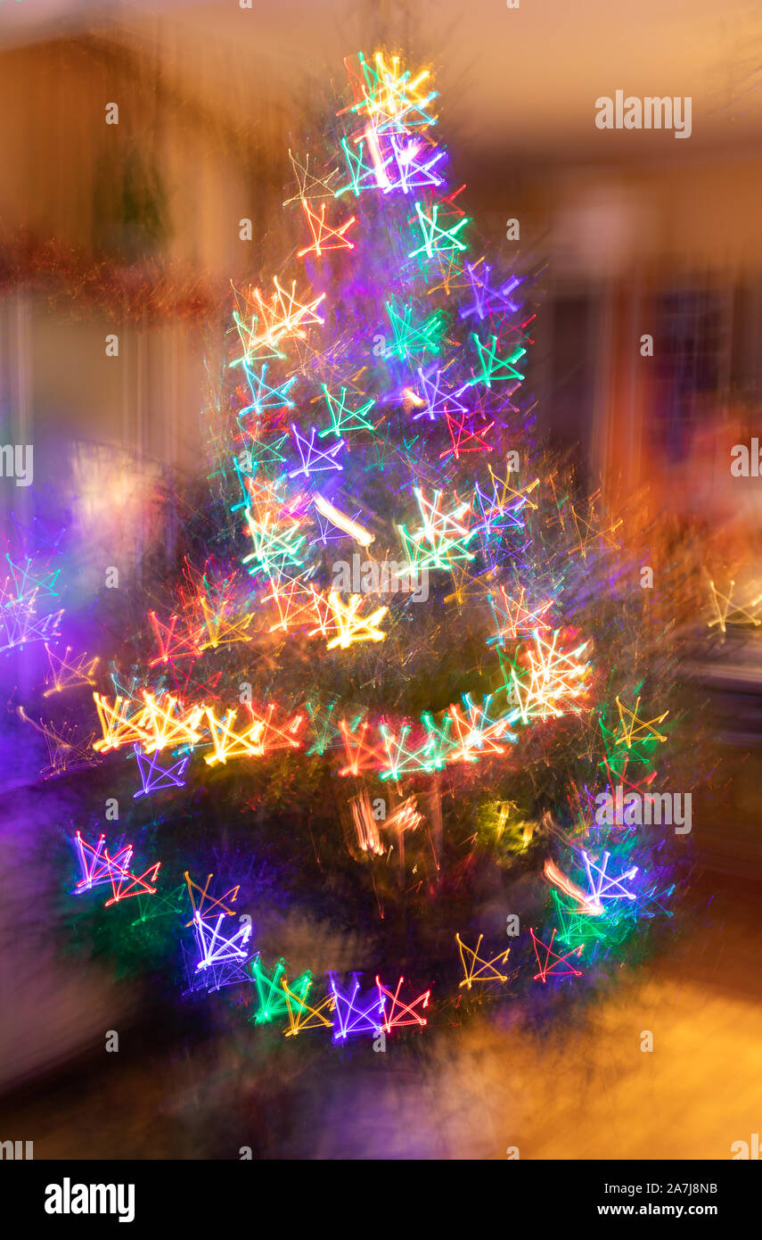 Abstract christmas neon background. Blurred garlands of lot of multicolored neon glowing stars on Christmas tree. Photographic effect of long exposure Stock Photo