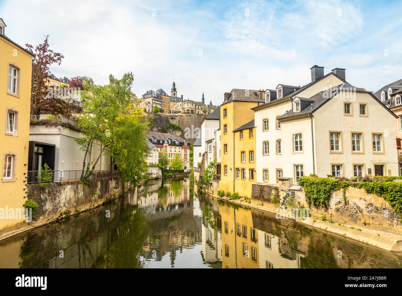 Alzette river bend with houses reflected in water and cathedral on the hill, Luxembourg city, Luxembourg Stock Photo