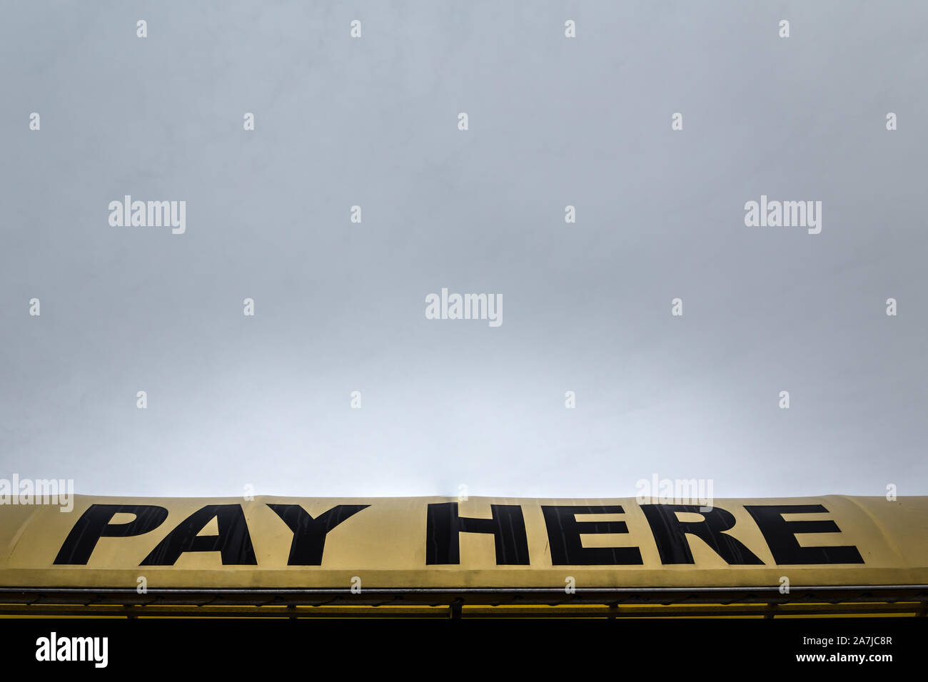 A big yellow sign that says pay here. Stock Photo