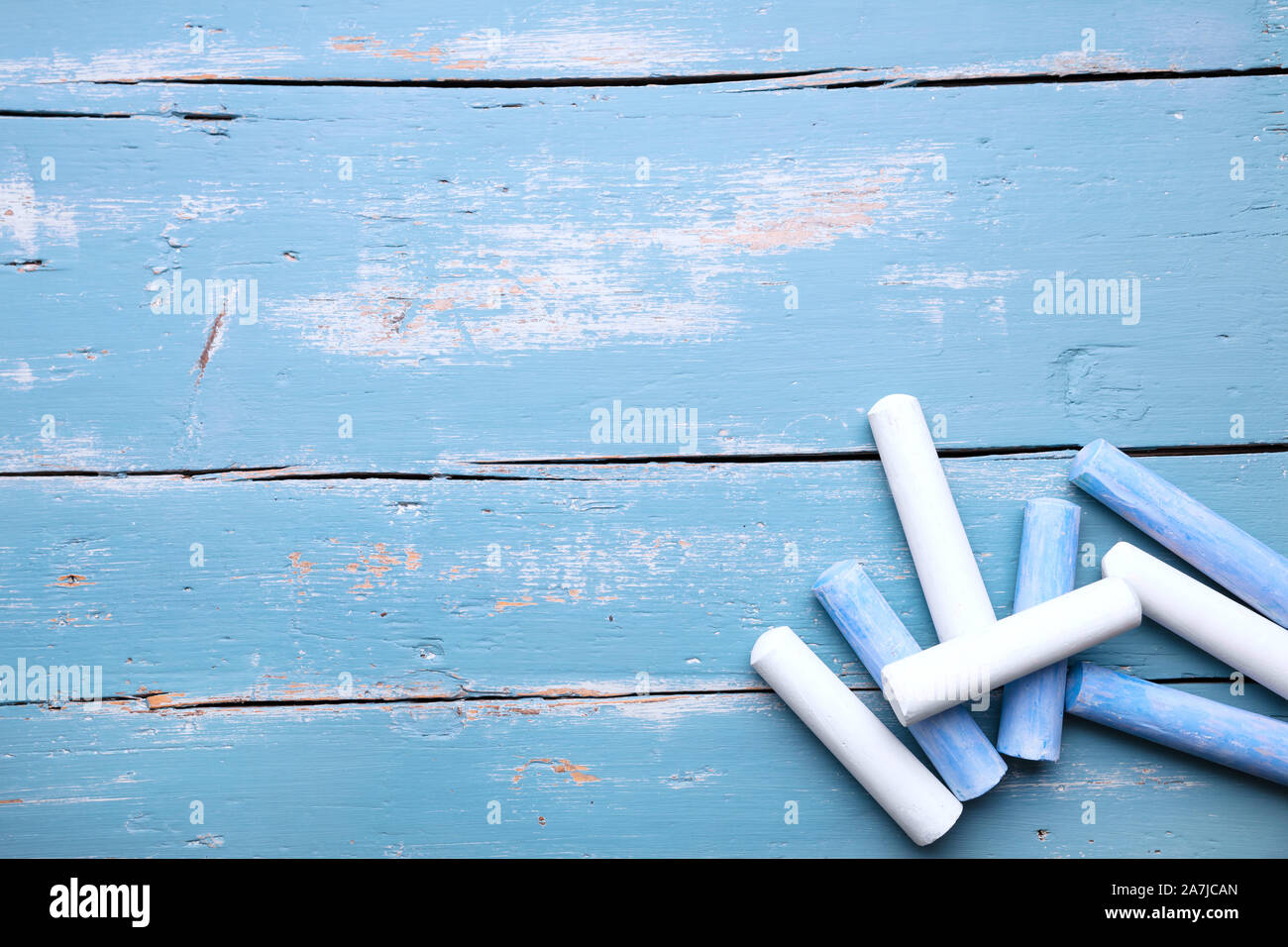 Blue and white crayon on wooden table with copyspace, concept eduaction