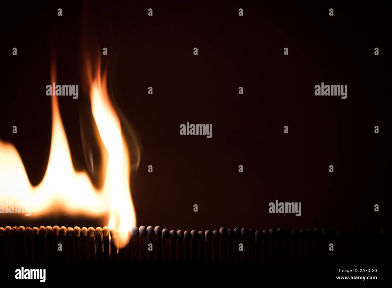 lots of matchsticks burning with a domino effect, fire with black background Stock Photo