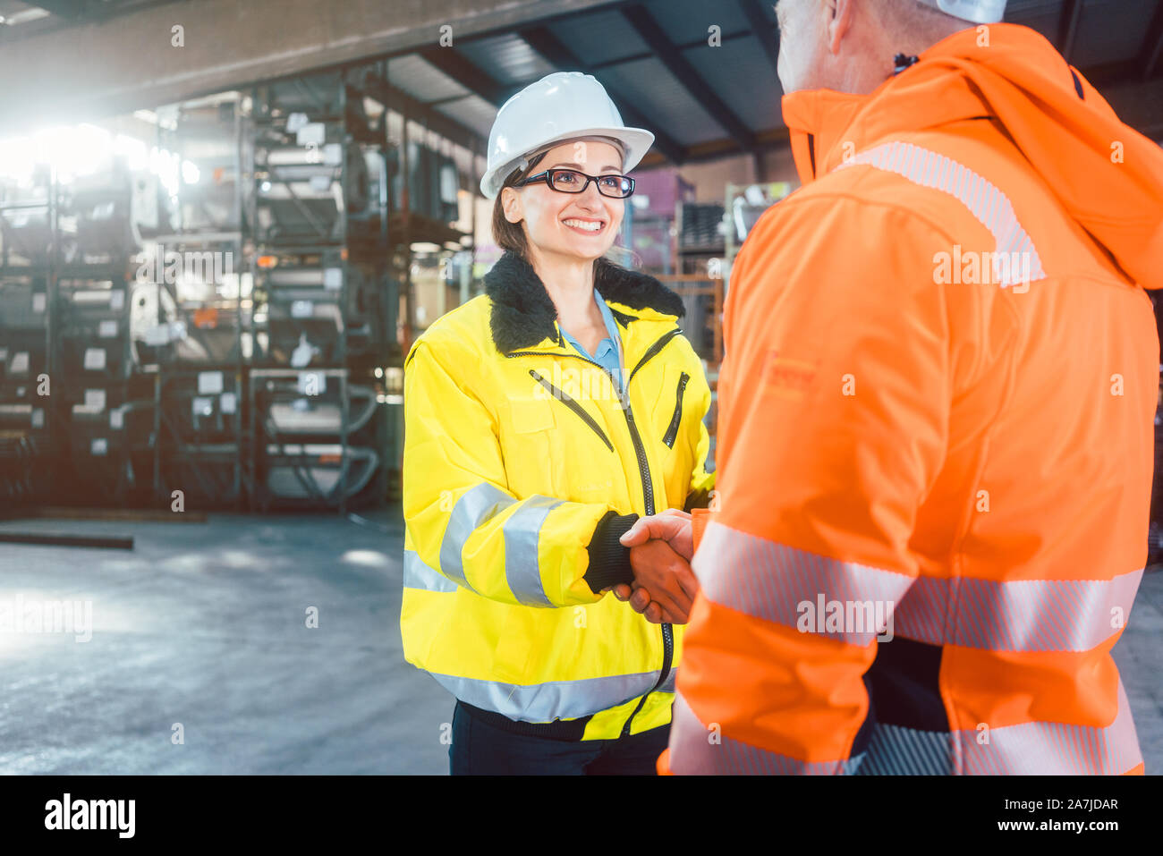 worker and customer in warehouse doing Handshake Stock Photo