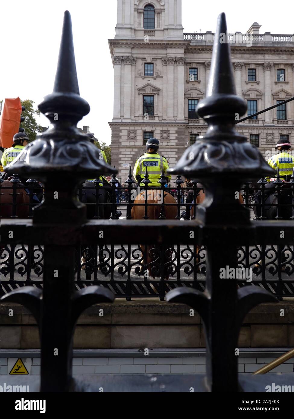 Mounted Metropolitian police officers behind iron railings at Westminster Station. Stock Photo