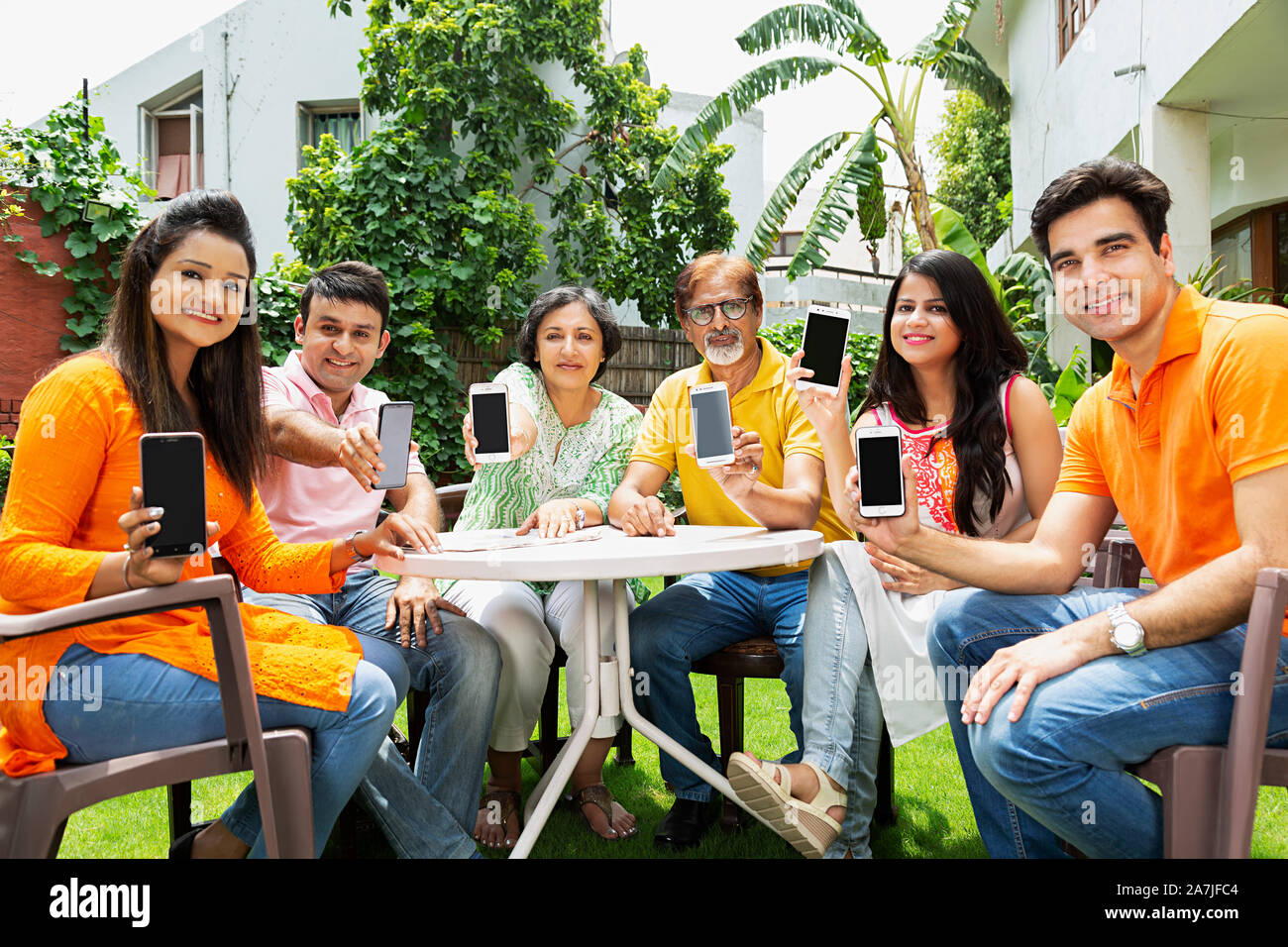 Groupof Happy Adult Family Parents And Adult Childrens Showing Cell