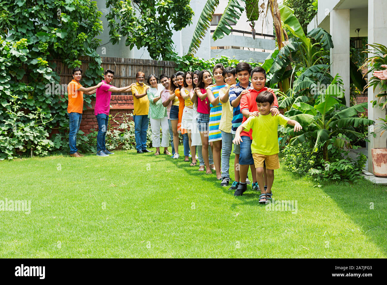 Group-of Happy Multi-generation Family walking Together in-train formation in-park of-their House Stock Photo