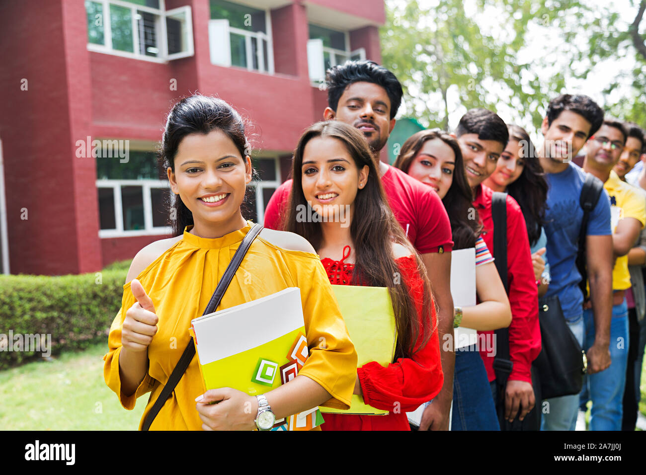 Group Indian College Students Friends Standing In-Line And Showing Thumbs-up In-Outside University Campus Stock Photo