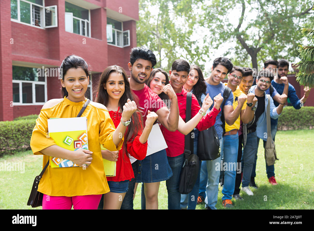 Group College Boys And Girls Students Friends Standing Queue Together And Hand-Fist Victory Celebrating At-Campus Building Stock Photo