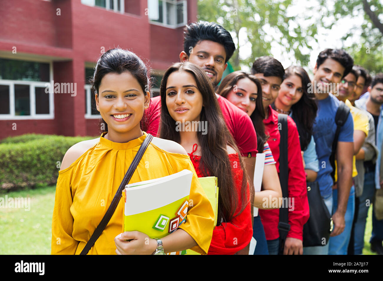 Confident college Boys And girls students Friends standing in a queue in-Outside University Campus Stock Photo