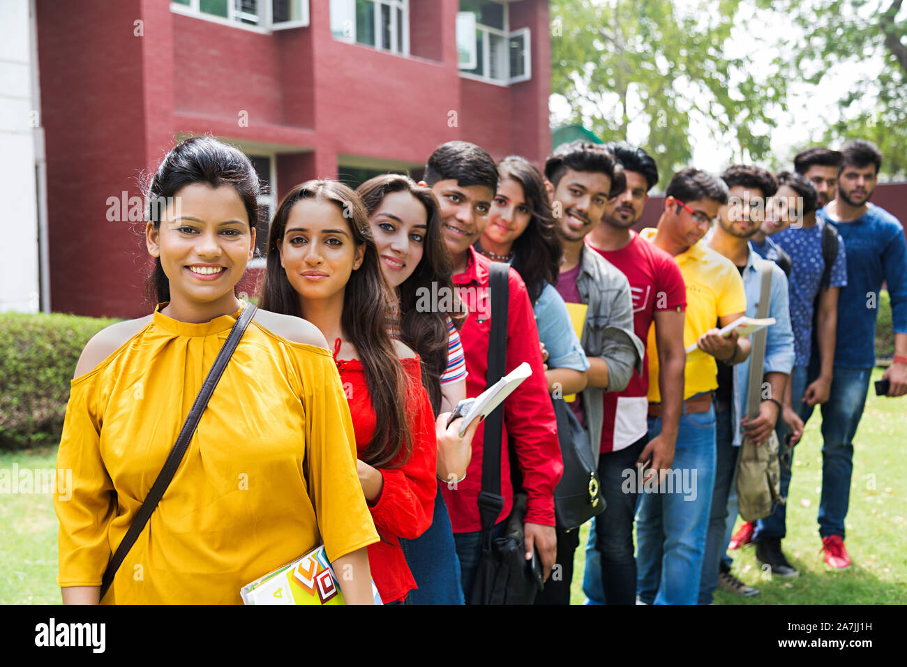 Group Of Young Male And Female College Students Friends Standing In-Line In-Outside Campus Building Stock Photo