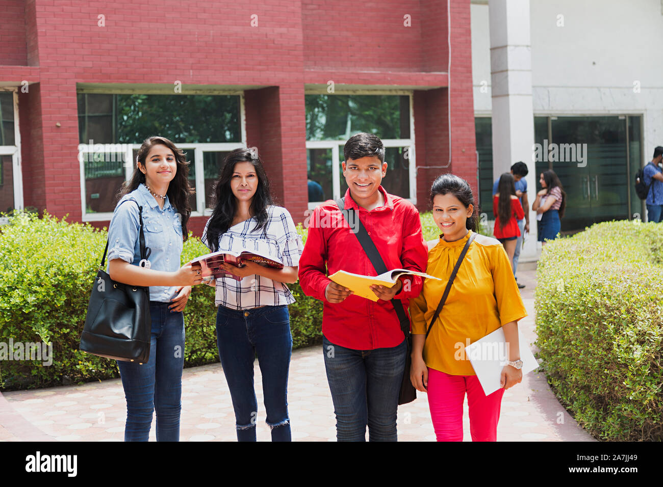 Four College Students Friends Together Reading Book Studying Education In-Outside university Campus Stock Photo