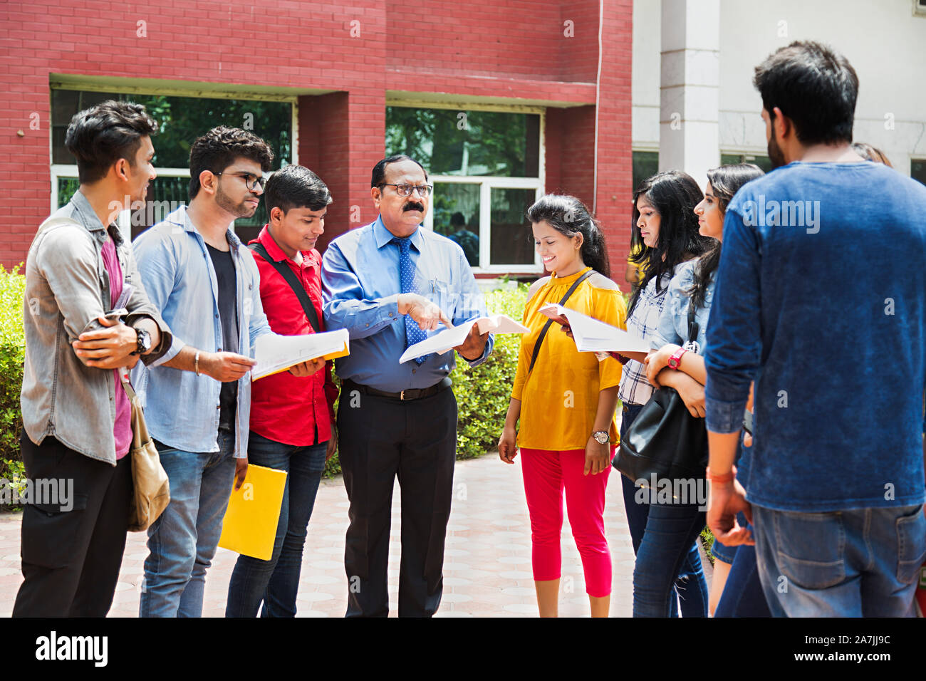 Group Of College Students With Professor Studying Book Education Discussion In-Outside Campus Stock Photo