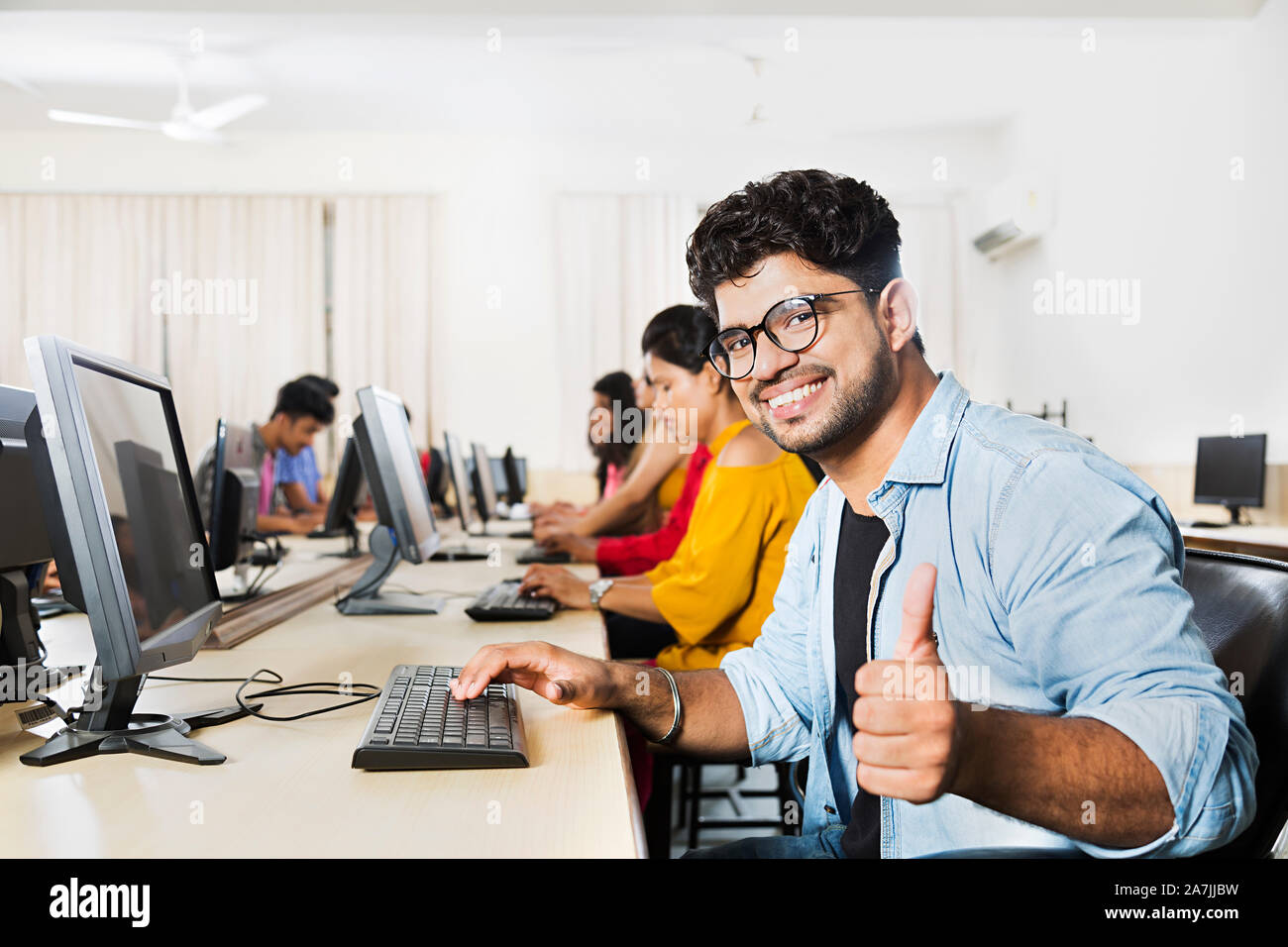 Young Male College Student Showing Thumbs-up With Computer Studying E ...
