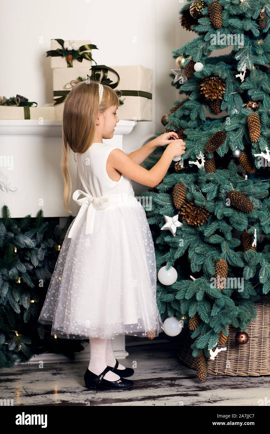 Cute Little Girl With Long Hair Decorating Christmas Tree