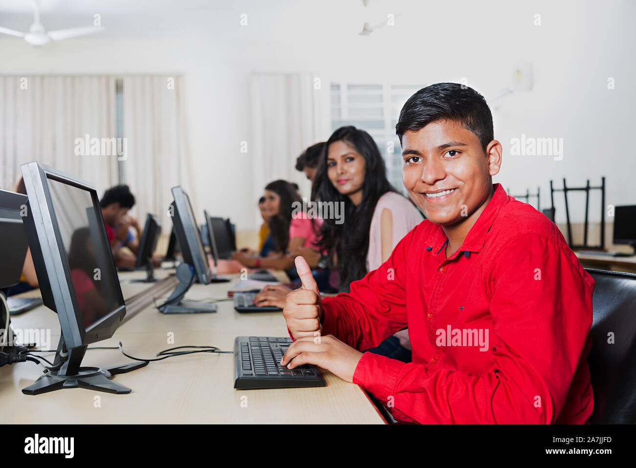Young Boy College Student Showing Thmbs-up With Computer At computer Classroom Stock Photo