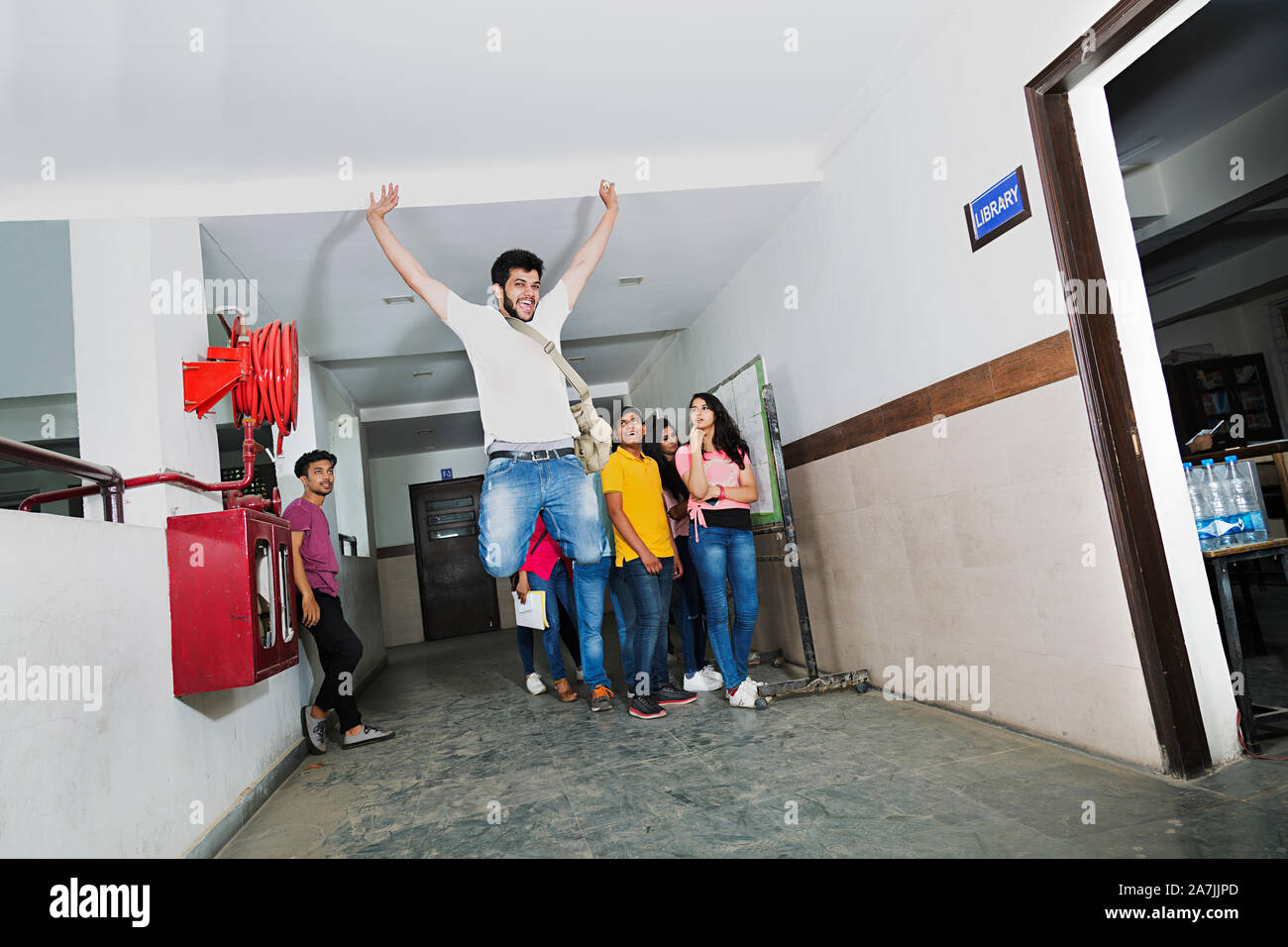 Young Boy College Student Jumping Celebrate their result With Classmates in-College Campus Stock Photo