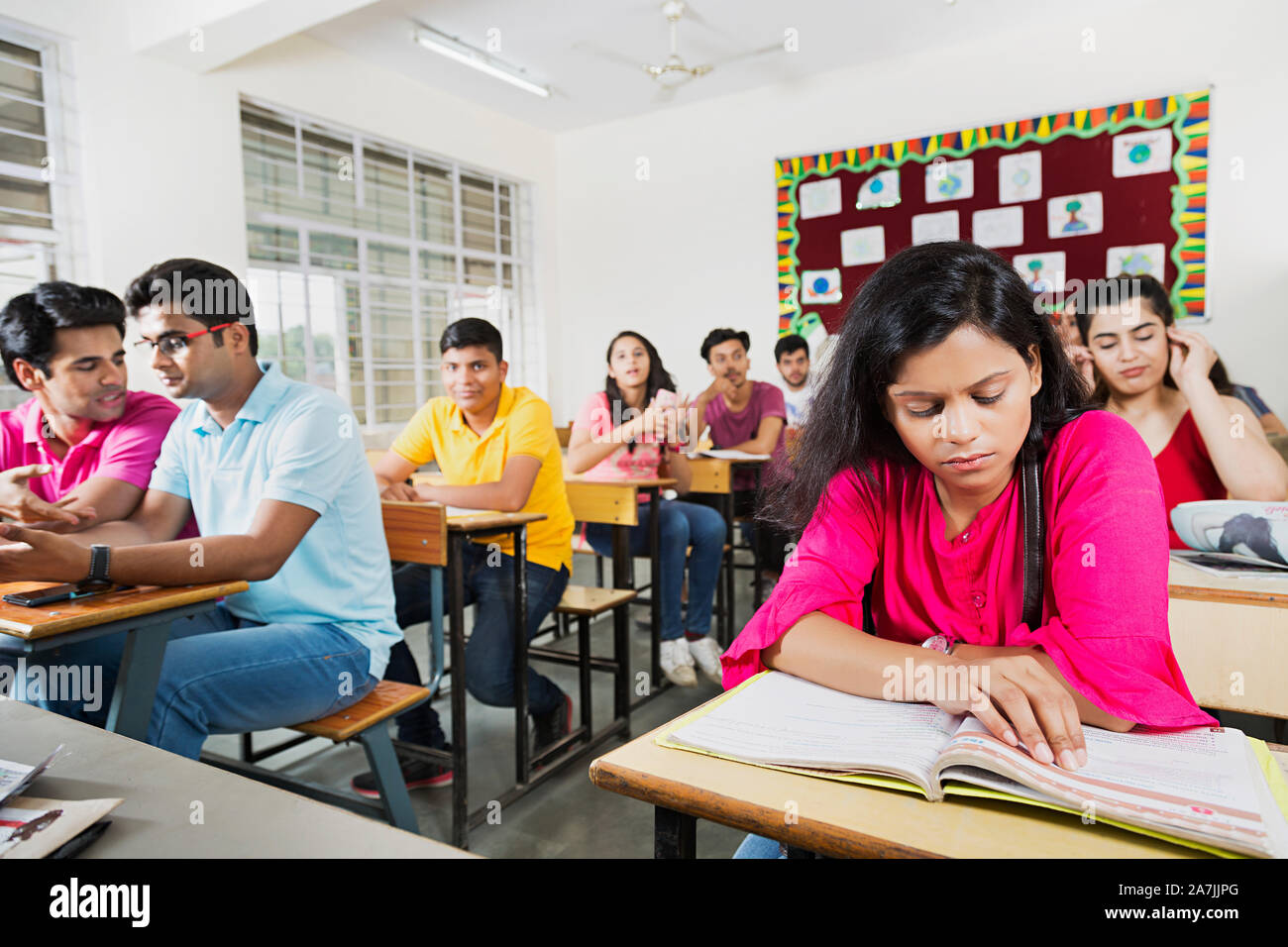 Young Female College Student Reading Book Studying With Classmates Preparing Exam In-Classroom Stock Photo
