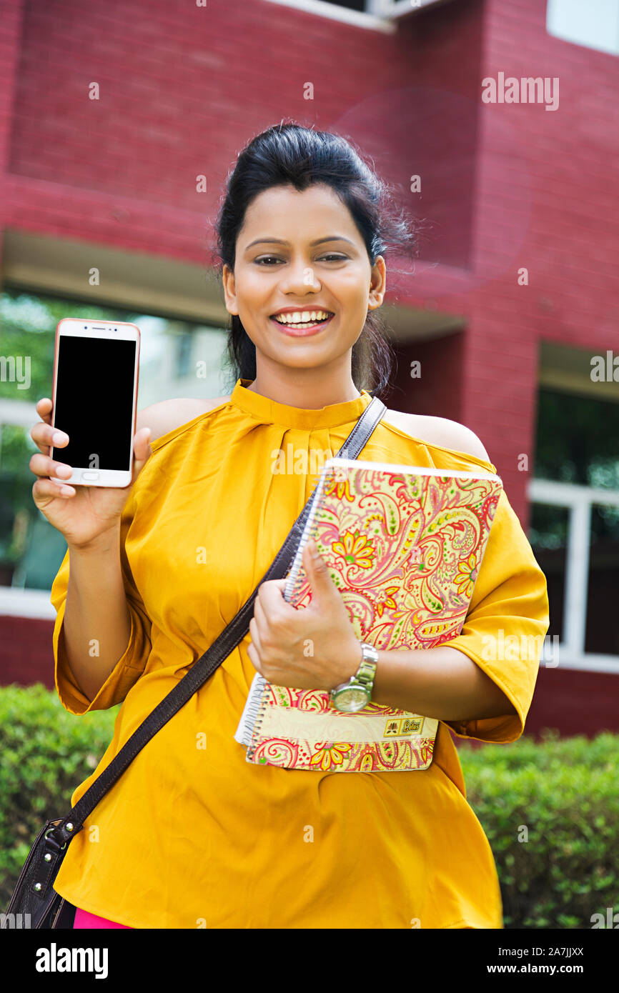 Happy young Woman College Student Holding Book While Showing Smart Phone Screen In-College University Campus Stock Photo