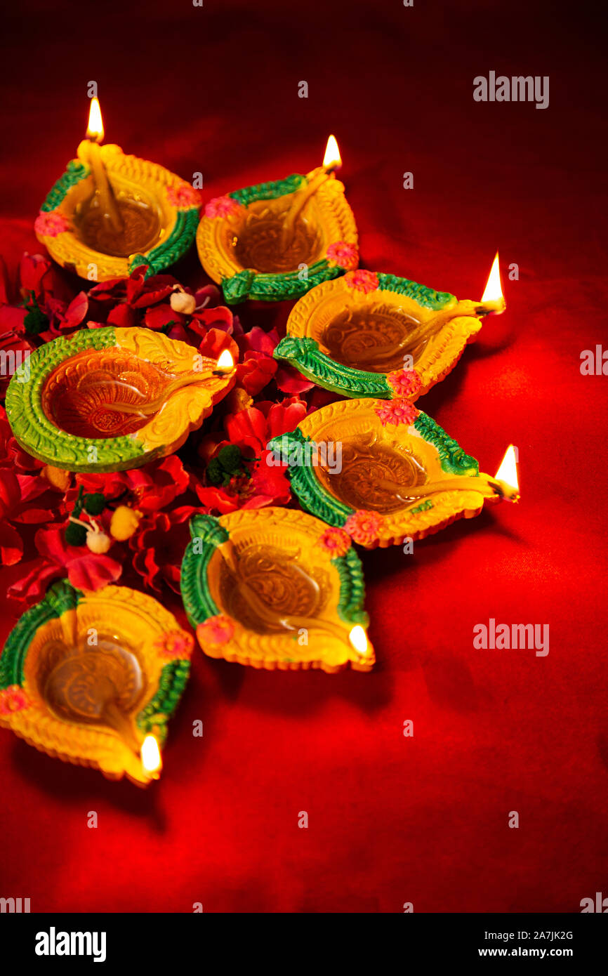 Close-up Burning Diyas Oil-lamp With Flowers-Petals Lighting On-Diwali Festival Celebration in-India Stock Photo