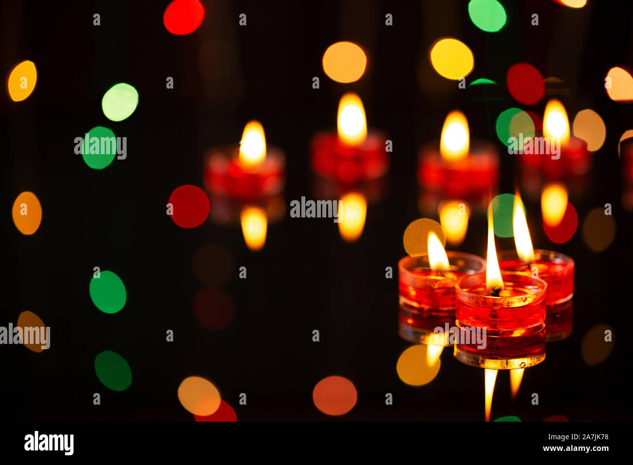 Indian Diwali Festival of-Lights focus on-foreground of-many burning tealight candles Stock Photo