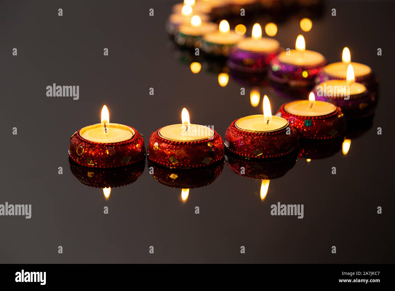 Burning Candles lighting in a curved line on Diwali Festival Celebration Stock Photo