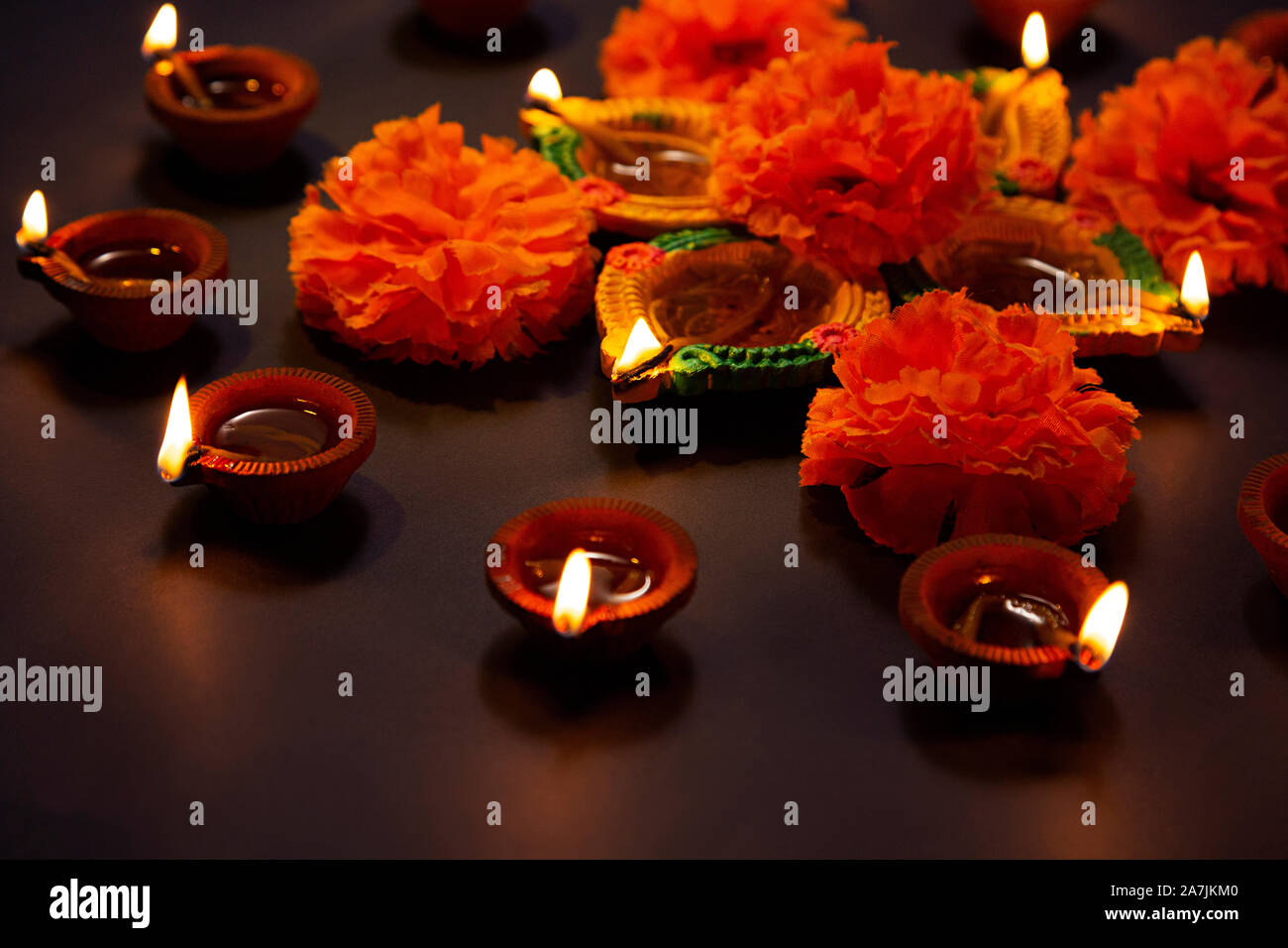 Burning Diya Oil-Lamp With Flowers Light Illuminated Diwali festival Celebration Nobody Stock Photo