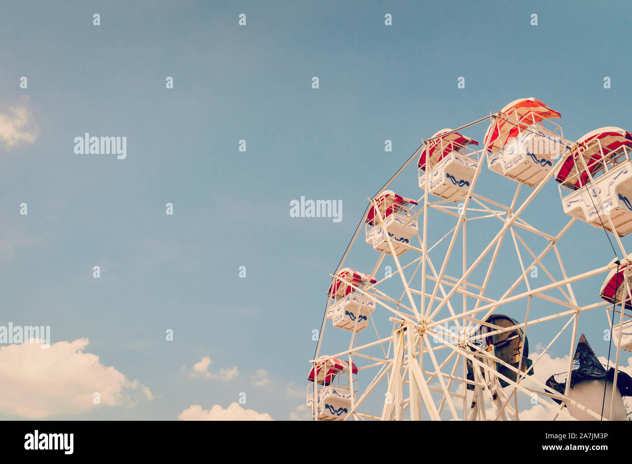 Ferris wheel on cloudy sky background with vintage toned. Stock Photo