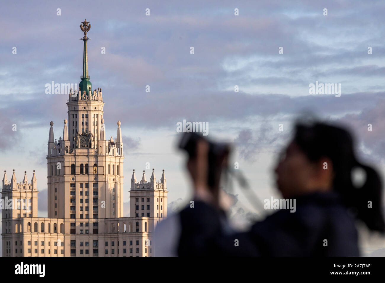 A tourist makes a photo against the background of Stalin skyscraper at Kotelnicheskya embankment in the center of Moscow, Russia Stock Photo