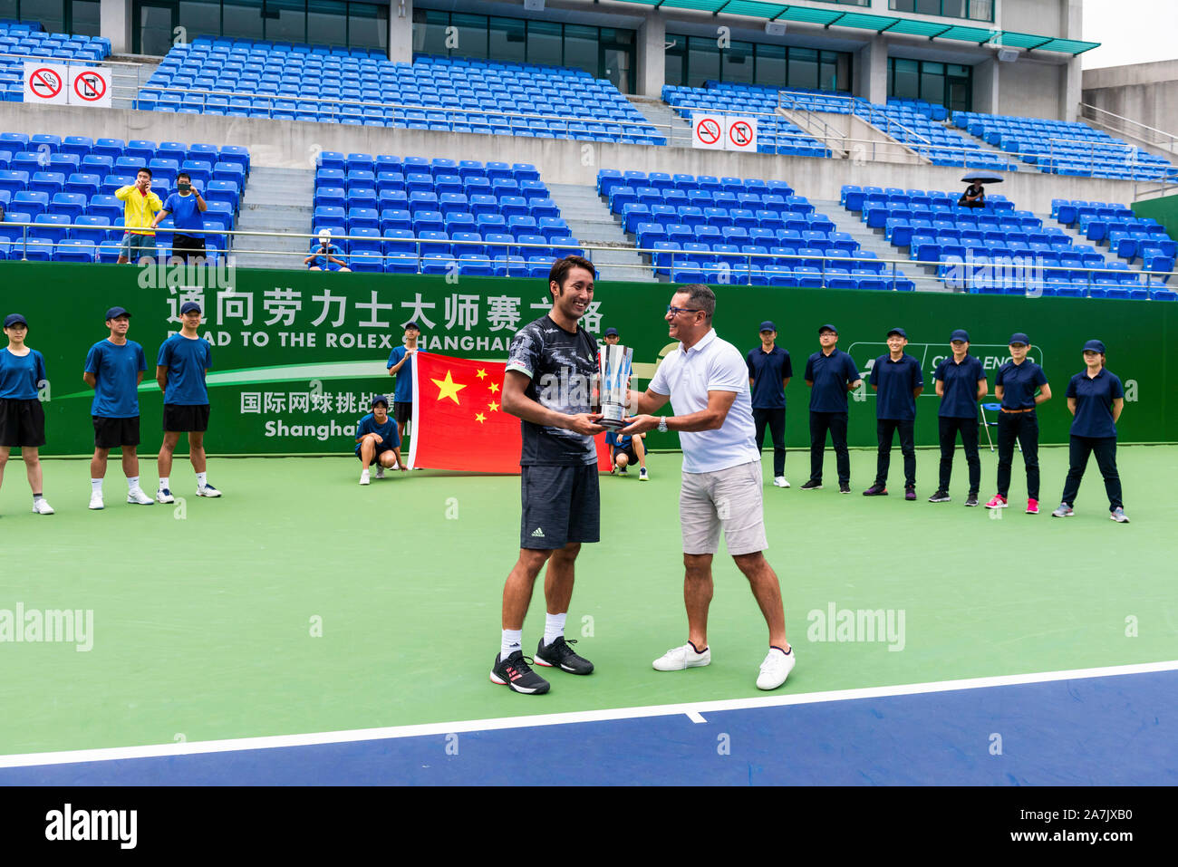 Japanese tennis player Yasutaka Uchiyama, left, is awarded the cup