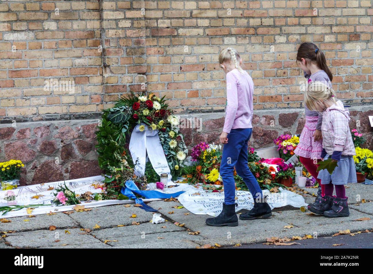 Terrorist attack Germany, Three young girls walking around synagogue wall, memory place, Halle Saale, Germany Stock Photo