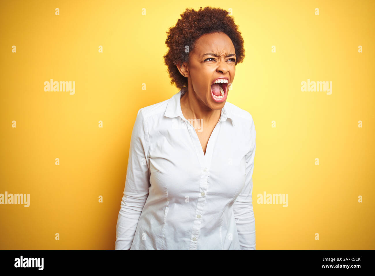 African american business woman over isolated yellow background angry ...