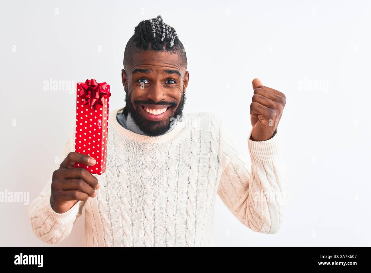 African american man with braids holding christmas gift over isolated ...