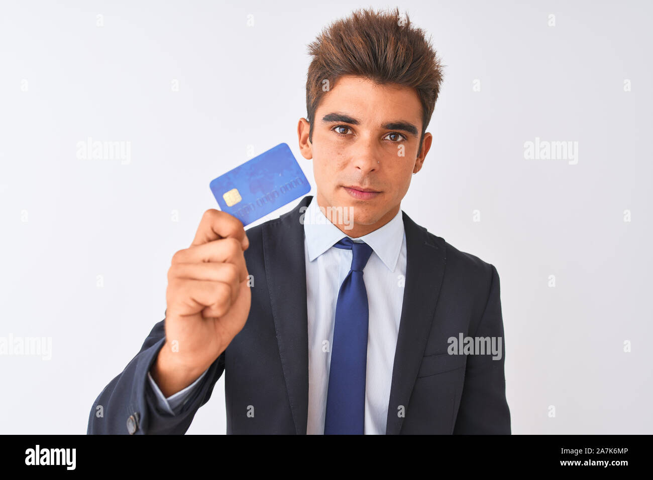 Young handsome businessman wearing suit holding credit card over ...