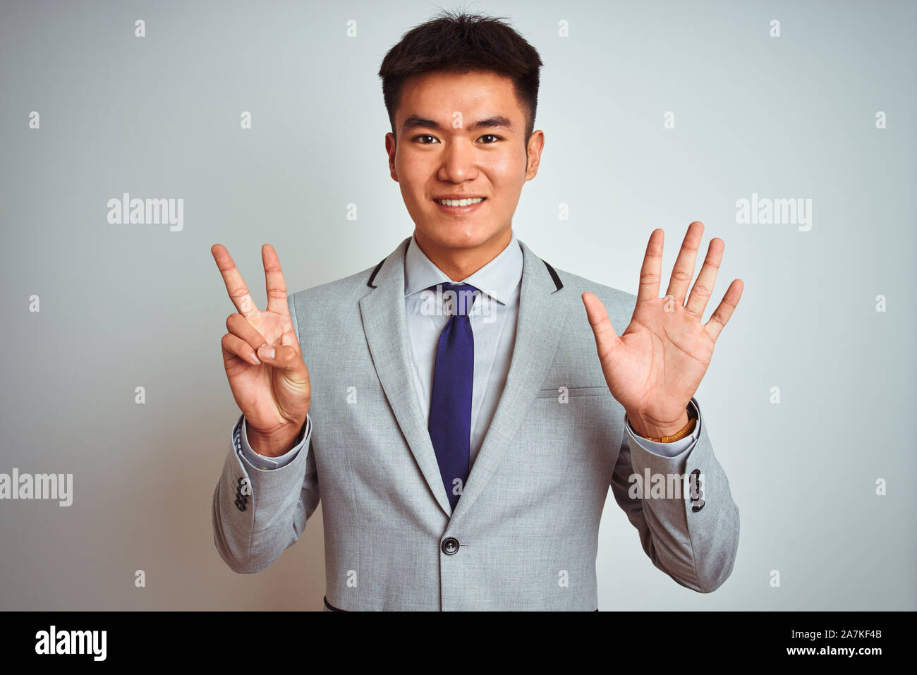 Asian chinese businessman wearing suit and tie standing over isolated ...