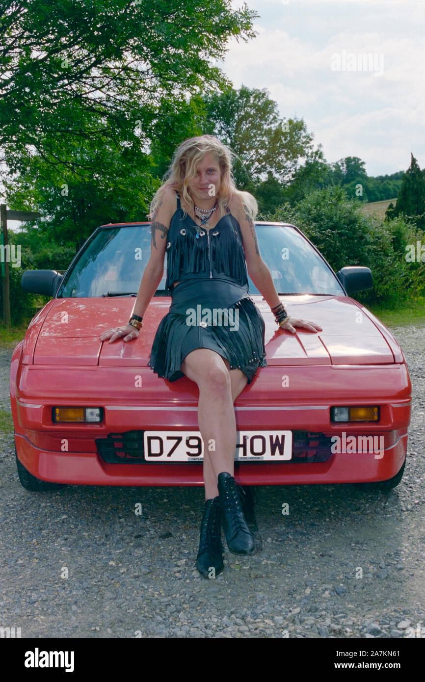female posing next to an original red toyota mr2 mk1 in the late 1990s hampshire england uk Stock Photo