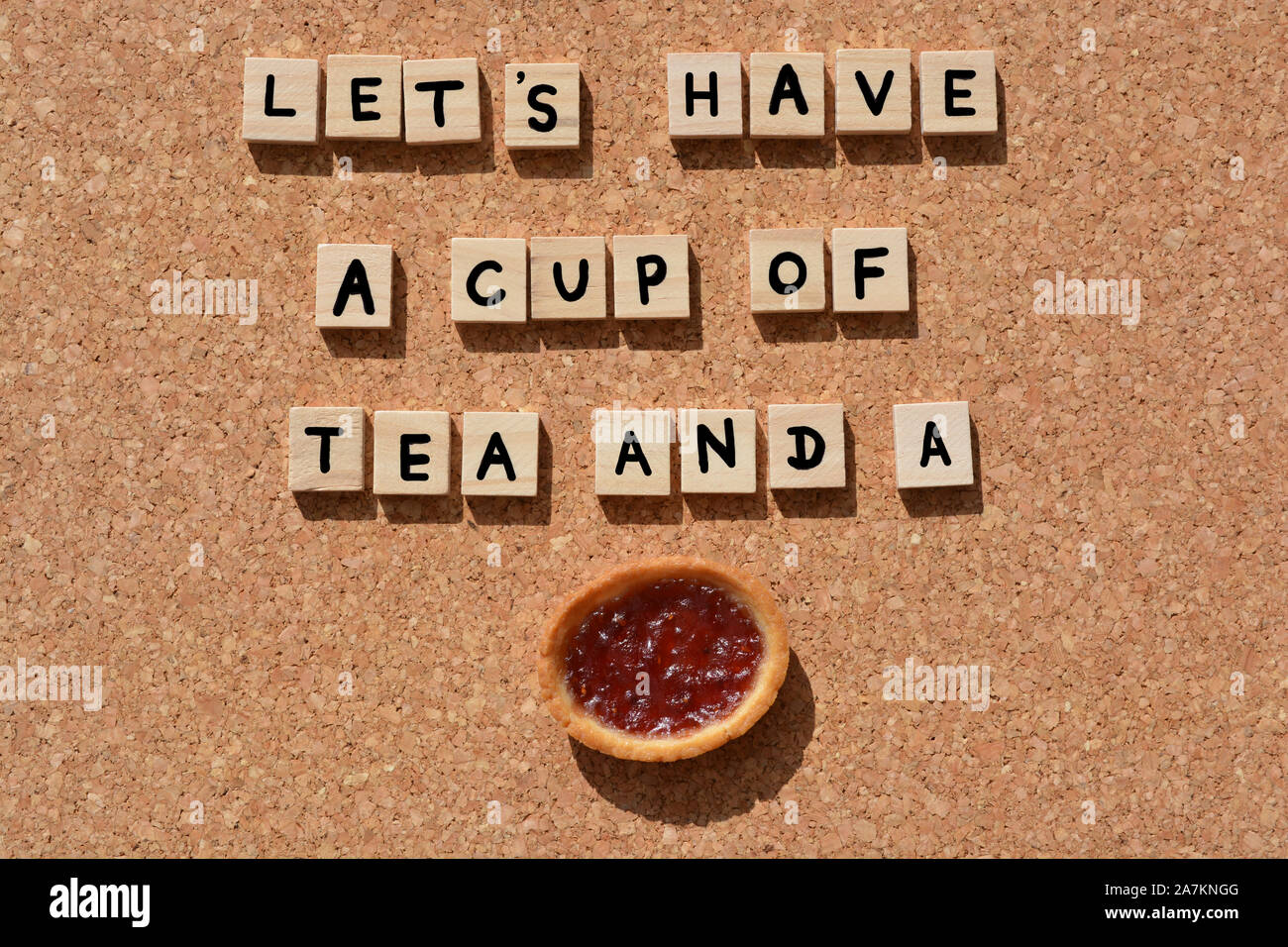 Lets Have A Cup of Tea And A jam tart, words in 3d wooden alphabet letters on a cork board background Stock Photo