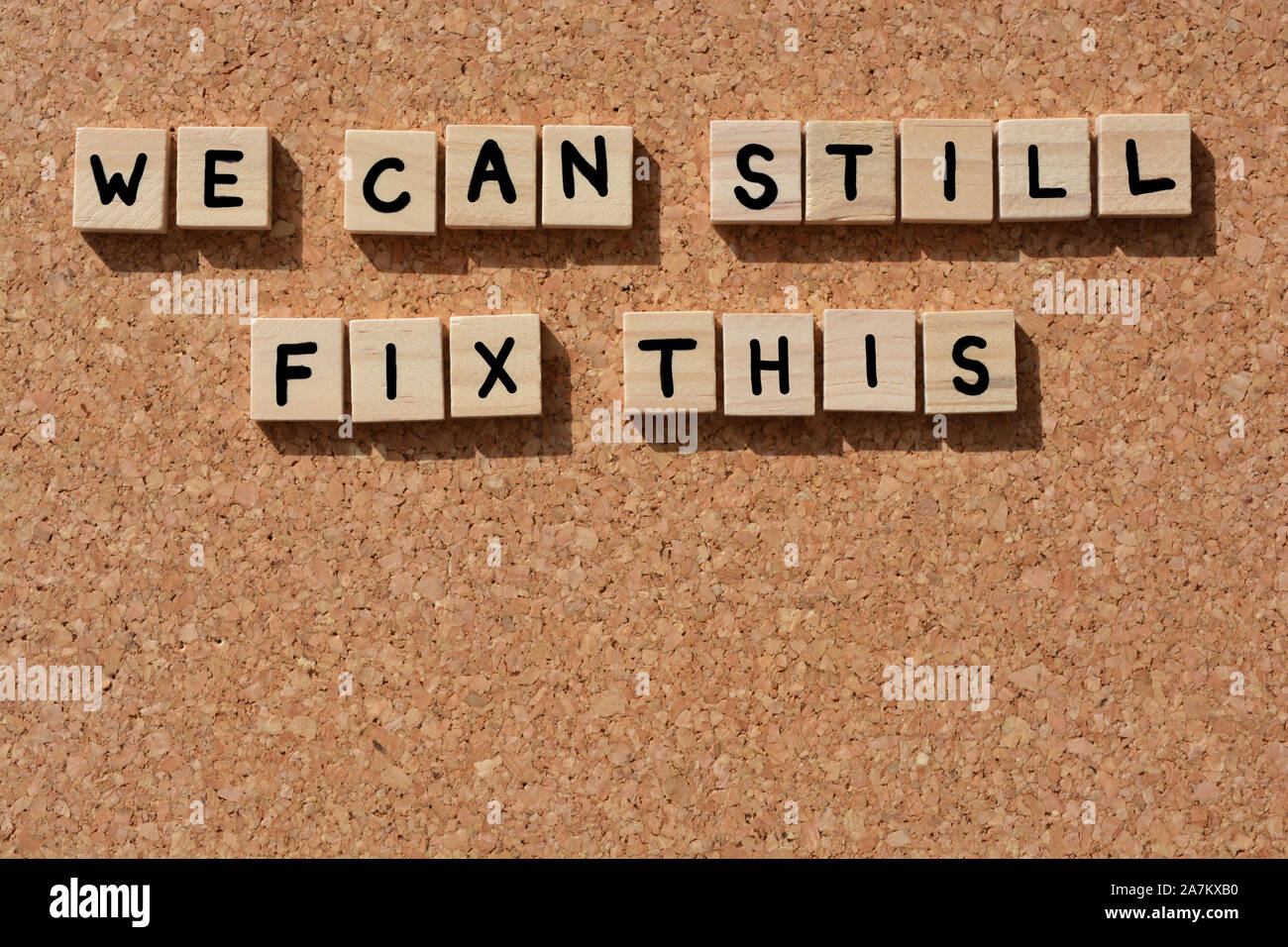 We Can Still Fix This, words in 3d wooden alphabet letters on a cork board background Stock Photo