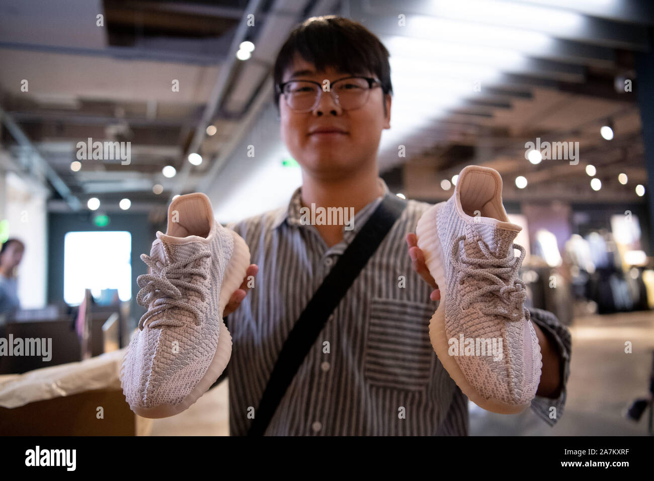A consumer demonstrates a pair of Adidas Yeezy, a collaboration between  German sportswear brand Adidas and American rapper Kanye West, at an Adidas  s Stock Photo - Alamy