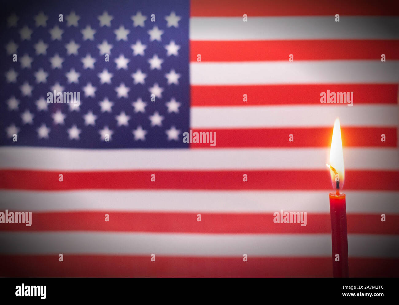 Burning candle on the background of the flag of Usa. The concept of mourning and sorrow in the country Stock Photo