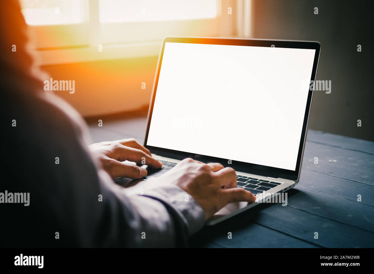 human hand in front of laptop on the table with blank, mockup image of ...