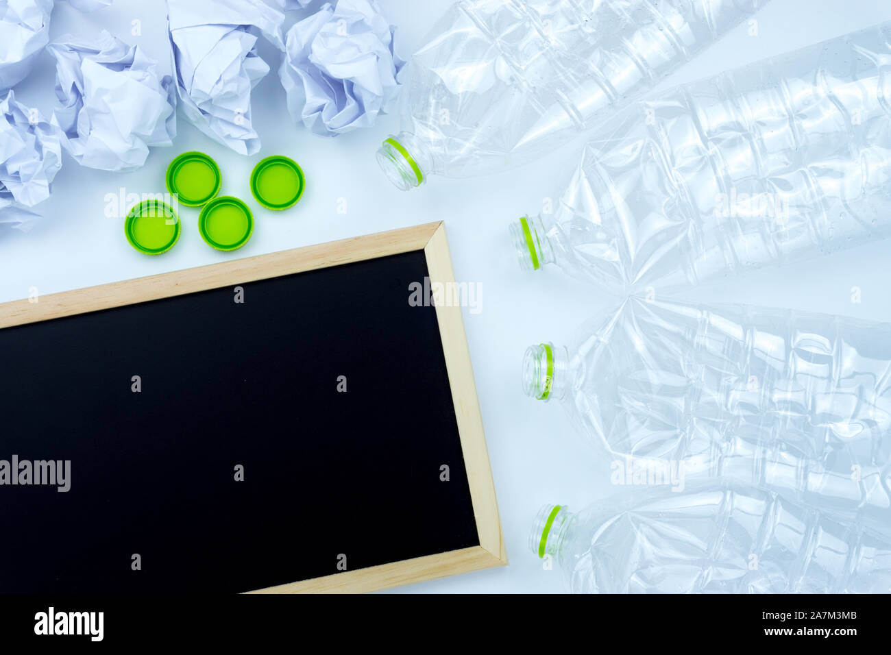 Recycling. The frame of used plastic bottle, blackboard and crumpled paper on white background with copy space. Recycle and reuse concept Stock Photo