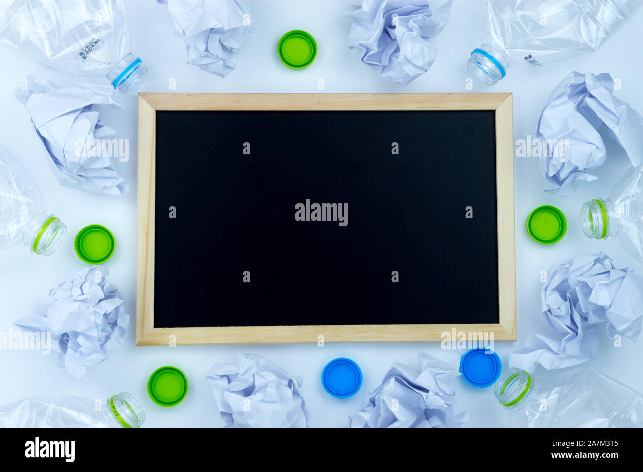 Recycling. The frame of used plastic bottle, blackboard and crumpled paper on white background with copy space. Recycle and reuse concept Stock Photo